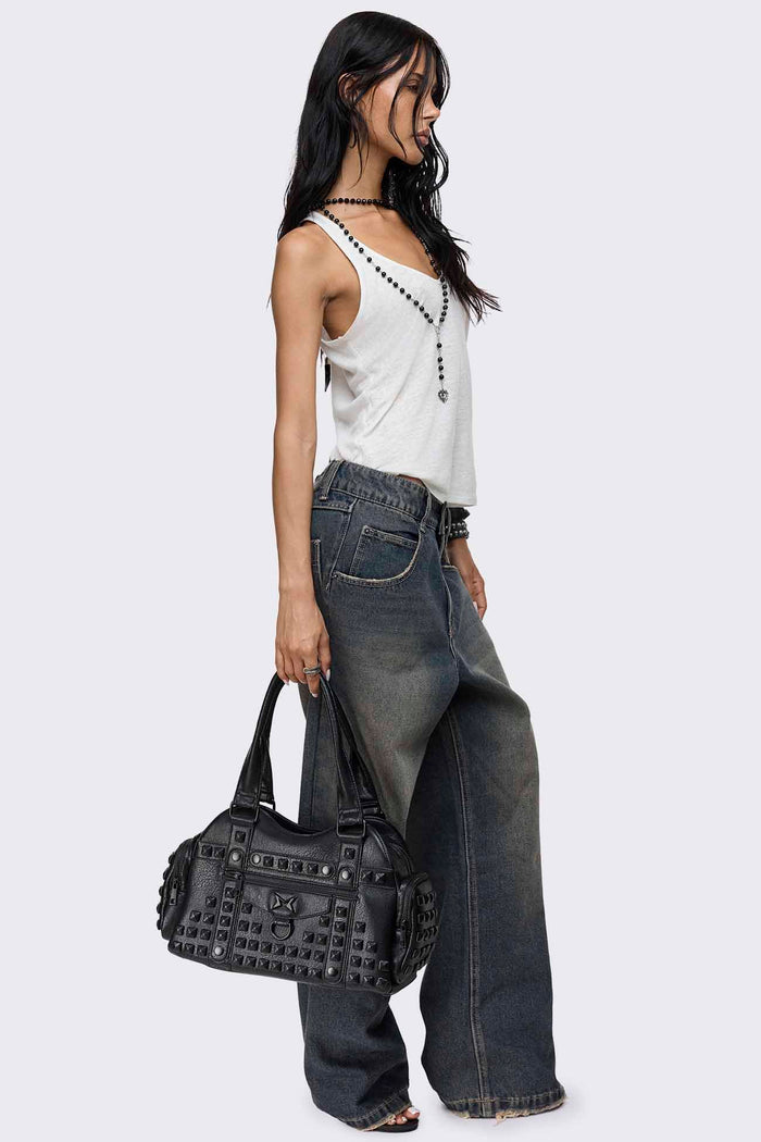 Black faux leather shoulder bag with pyramid studs, front zip pocket, side pockets and two top handles.