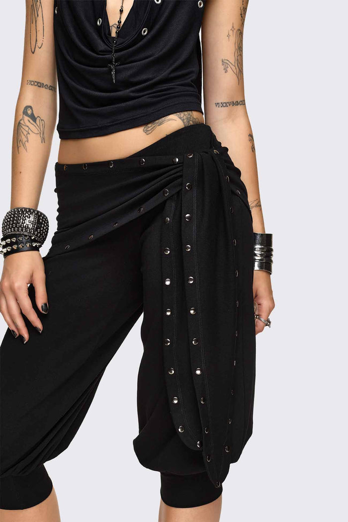 Black capri pants with wrap overskirt tie detail, silver studs, balloon fit and elasticated cuffs.