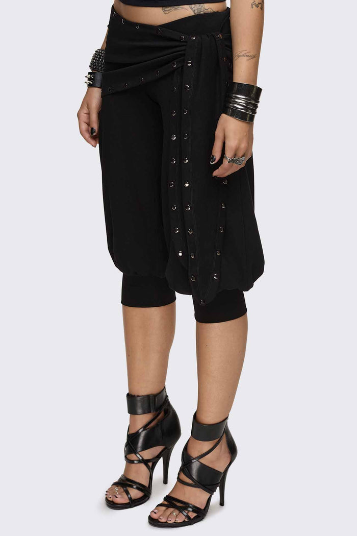 Black capri pants with wrap overskirt tie detail, silver studs, balloon fit and elasticated cuffs.