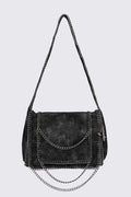 Black faux suede shoulder bag with chain trim, layered chains and fold-over flap in a grunge Y2K style.