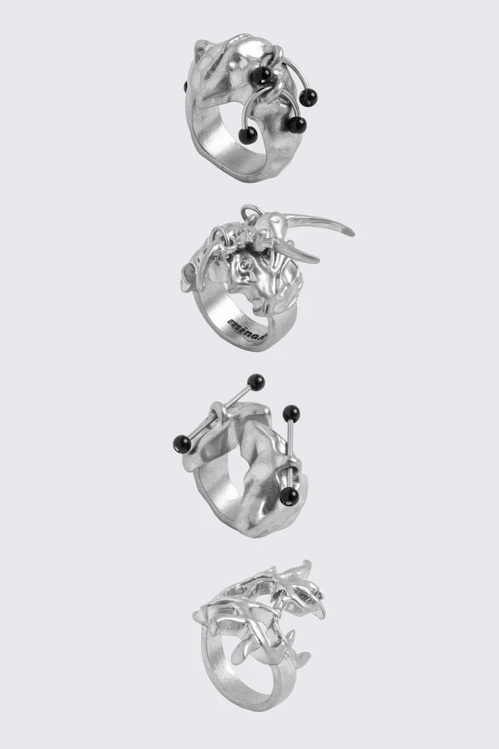 Antique-silver zinc ring set with sigilism shapes and black piercing details in a cyber goth style.