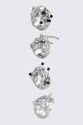 Antique-silver zinc ring set with sigilism shapes and black piercing details in a cyber goth style.
