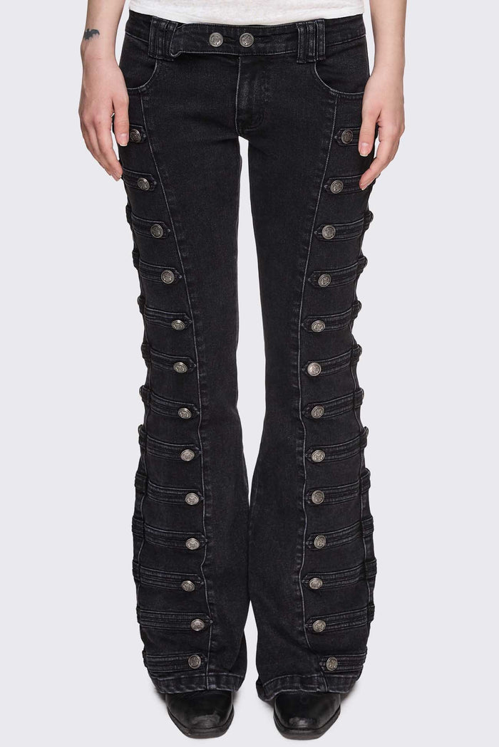 Black washed denim flare jeans with drummer-style button panels and military detailing in a dark grunge vibe.