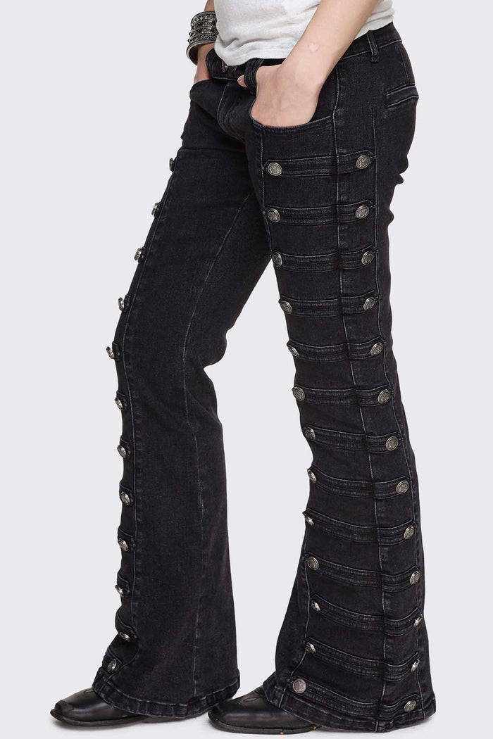 Black washed denim flare jeans with drummer-style button panels and military detailing in a dark grunge vibe.