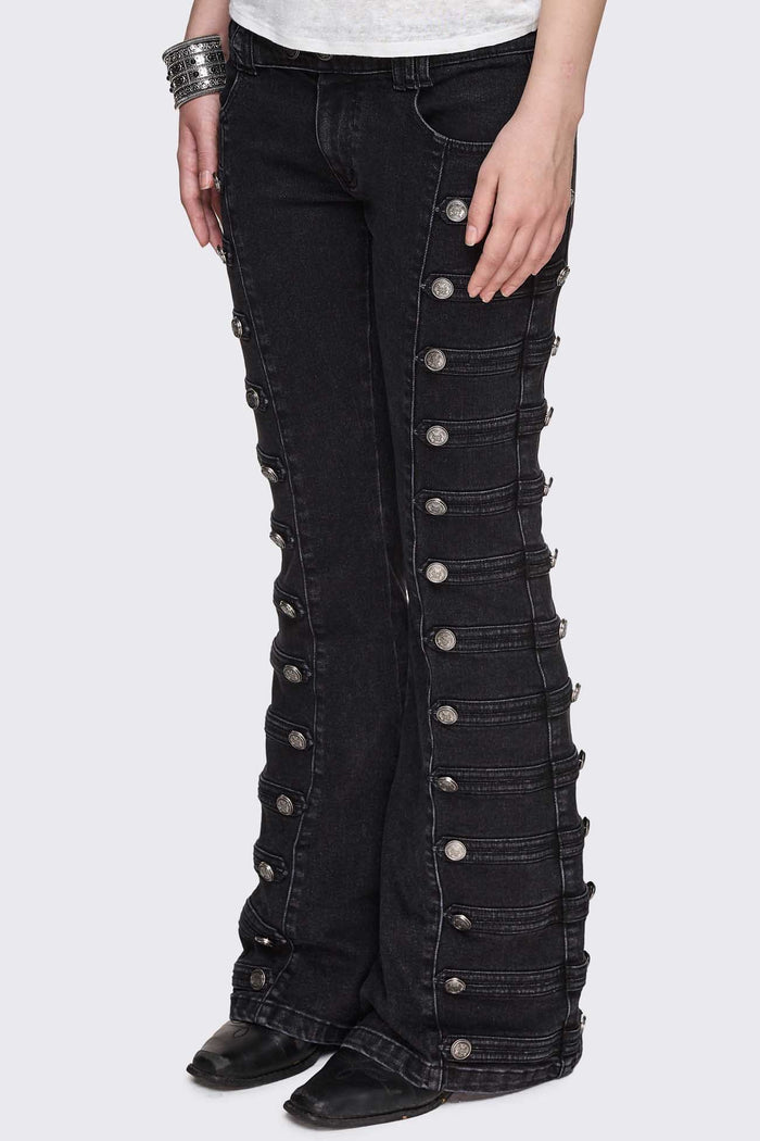 Black washed denim flare jeans with drummer-style button panels and military detailing in a dark grunge vibe.