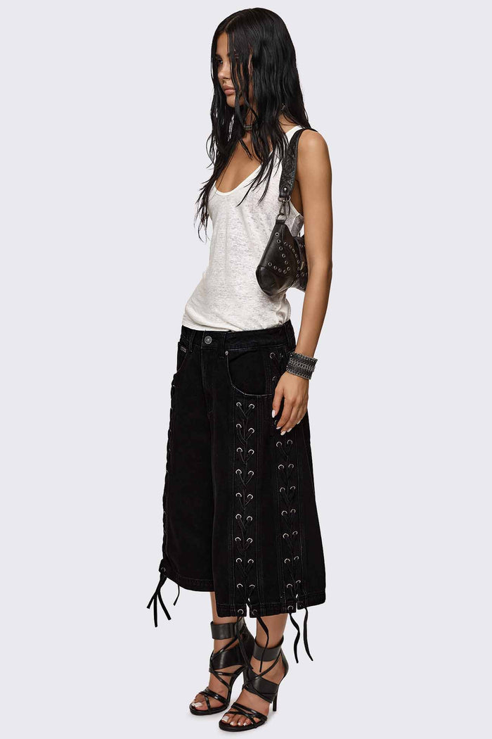 Black washed denim jorts with lace-up corset sides, baggy wide-leg fit and grunge aesthetic.
