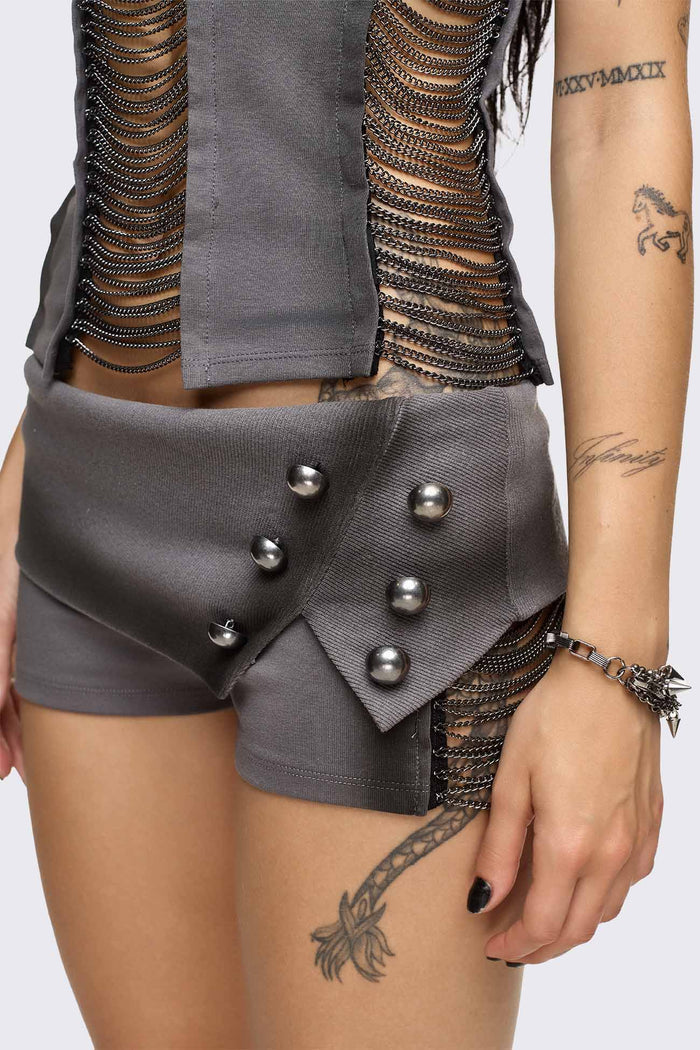Grey washed jersey hot pants with side cutouts, silver chains and a studded fold-over low rise waistband.